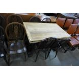 An oak draw-leaf refectory table and six wheelback dining chairs