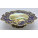 An Aynsley tazza, with a blue and gold border and decoration, having a central hand painted
