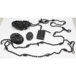 A Whitby jet 'book' pendant, two brooches and bracelet, and a black bead necklace, requires repair