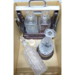 A two bottle tantalus with key and two decanters, one with stand (with silver band) **PLEASE NOTE