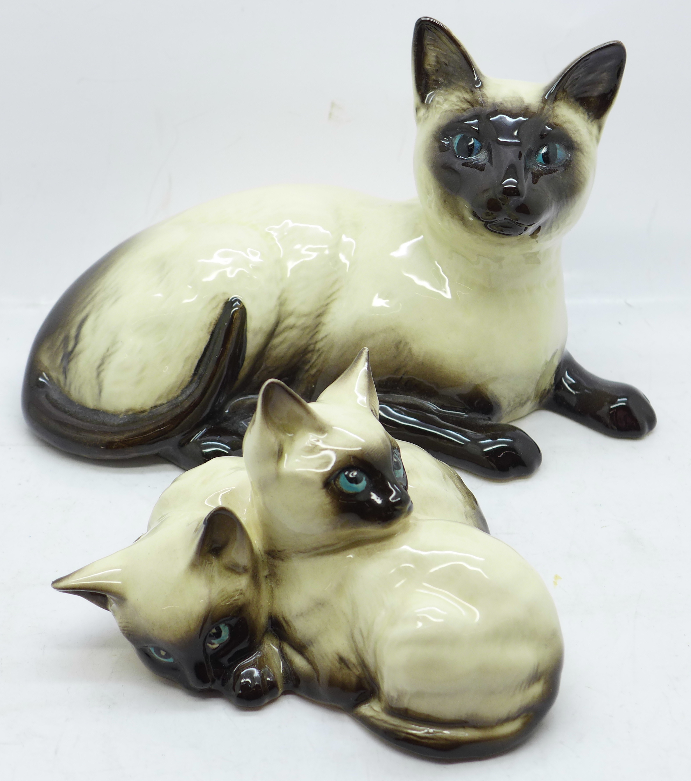 Two Royal Doulton Siamese cat figures, smaller figure with small chip to one ear
