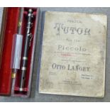 A cased Piccolo and a Practical Tutor instruction book