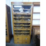 A mid 20th Century oak haberdashery shop cabinet