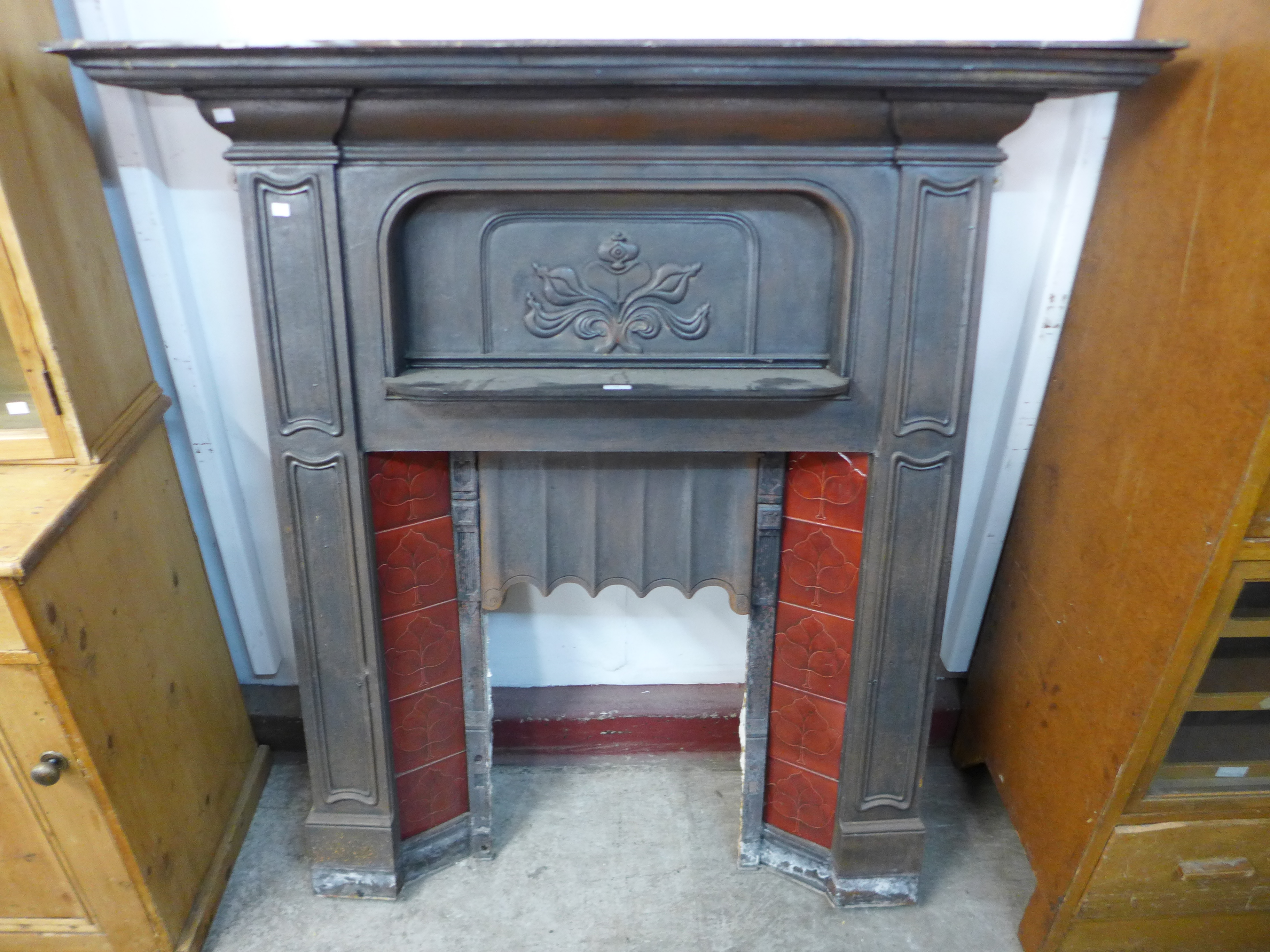 An Art Nouveau cast iron fire insert