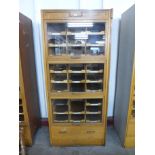 A mid 20th Century oak haberdashery shop cabinet