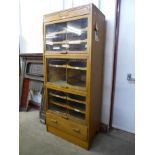 A mid 20th Century oak haberdashery shop cabinet