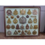 A framed set of 27 regimental cap badges plus buttons