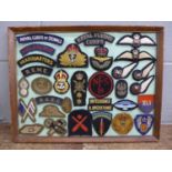 Framed cloth military badges, 31 in total