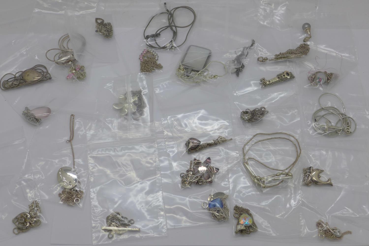 Twenty five silver pendants and chains