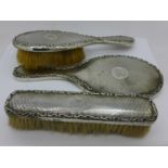 A three piece silver brush and mirror set