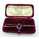 A yellow metal and amethyst bar brooch, 3.1g, boxed