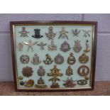 A framed set of 27 regimental cap badges plus buttons and shoulder titles