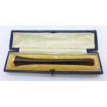 An amber and gold topped cigarette holder, boxed