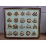 A framed set of 20 regimental cap badges and others