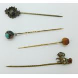 Four assorted stick pins including yellow metal