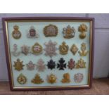 A framed set of 24 regimental cap badges