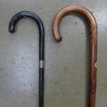 An ebonised walking cane with silver collar and one other walking stick