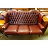 A red leather Chesterfield wingback settee