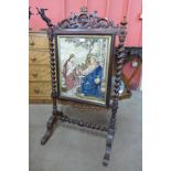 A Victorian rosewood barleytwist fire screen, embroided with religious scene