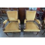 A pair of French Baroque Revival carved walnut and upholstered fauteuils