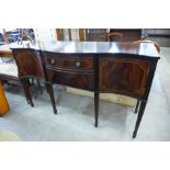 A Regency style inlaid mahogany serpentine sideboard