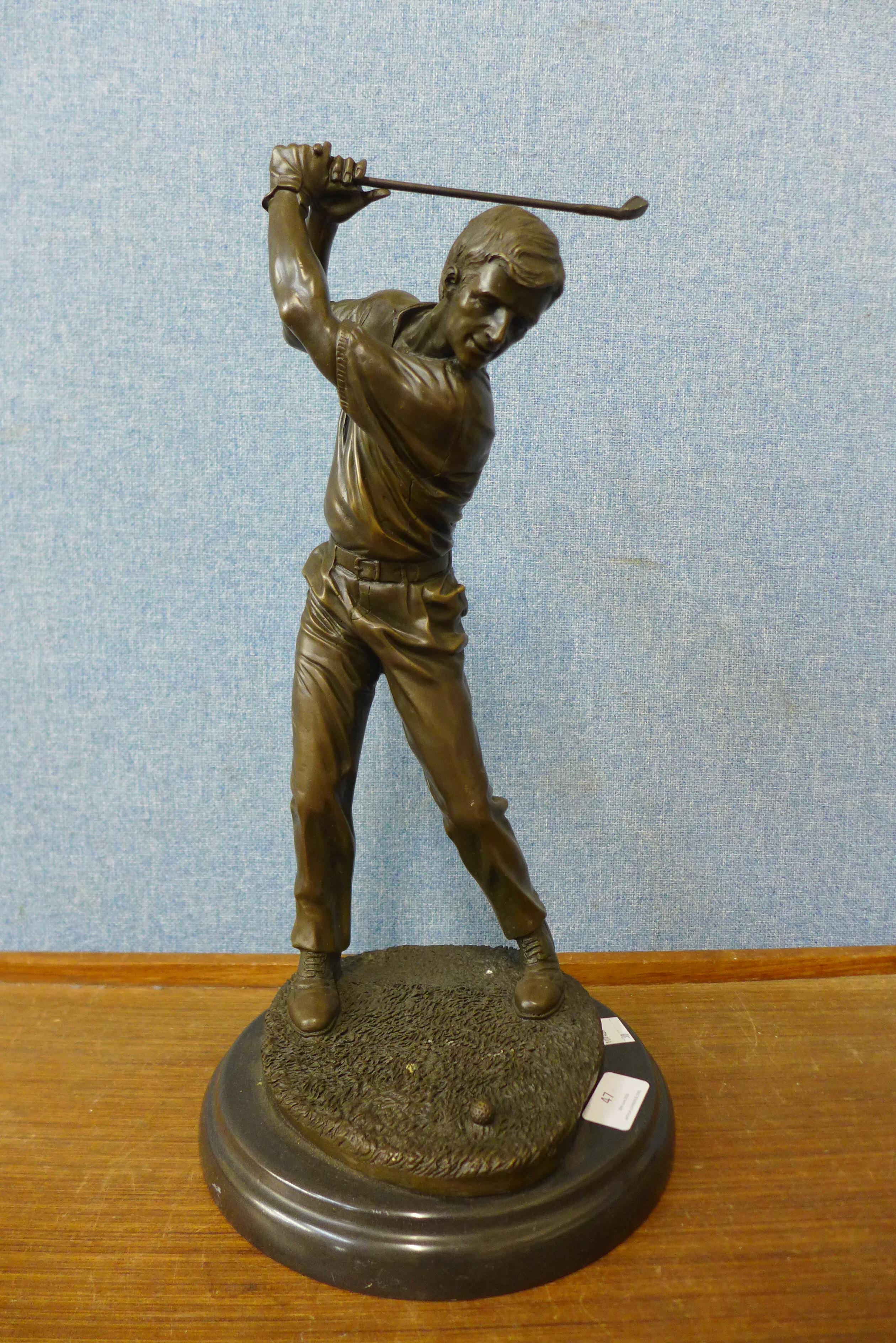 A bronze figure of a golfer