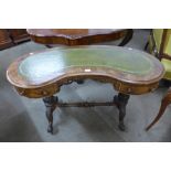 A Victorian walnut kidney shaped writing table