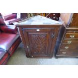 A George III carved oak hanging corner cupboard