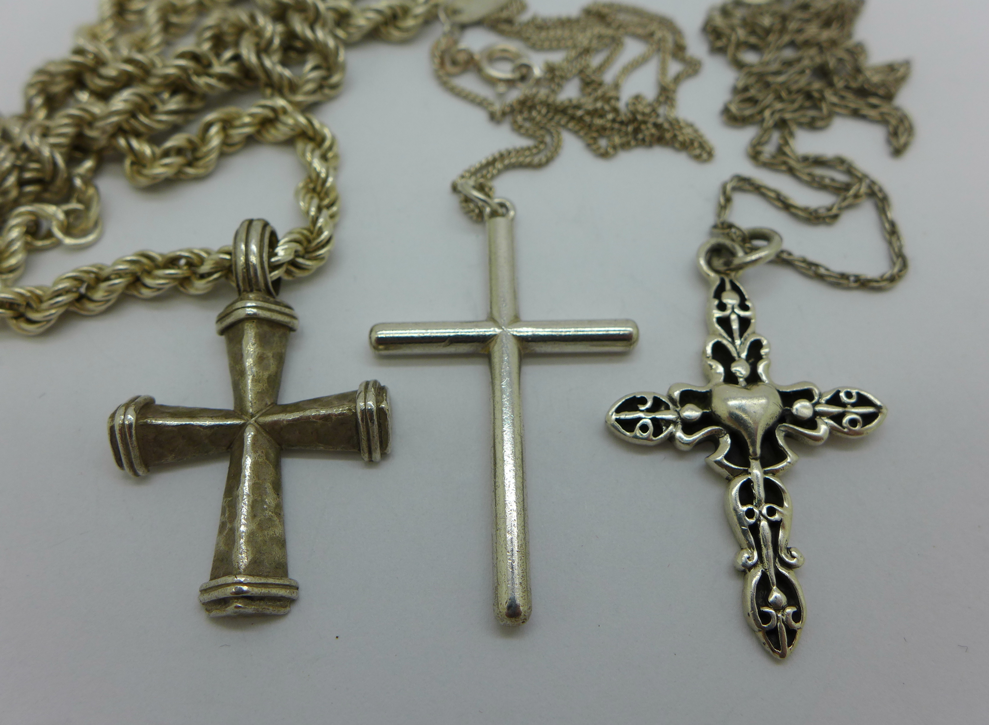Three silver cross pendants with chains, 33g