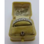 A white metal and diamond eternity ring, circa 1920's/30's, (tests as platinum), 3.7g, U