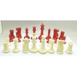 A carved ivory chess set with stained red pieces, one white pawn missing, King 85mm, some a/f