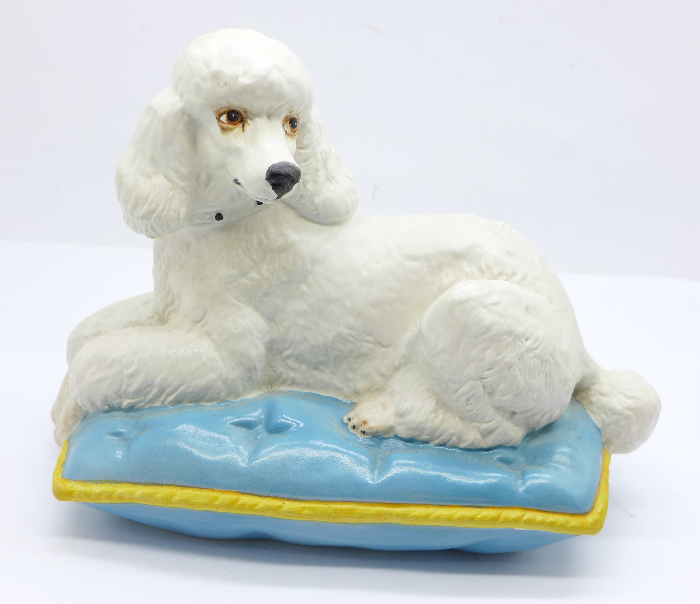 A Royal Doulton model of a poodle laying on a cushion