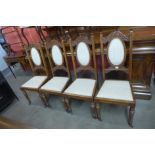 A set of four Edward VII carved walnut dining chairs