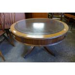 A mahogany and leather topped drum shaped coffee table