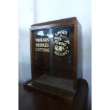 A mahogany counter top shop display cabinet, bearing Singer Sewing Machines inscription to doors