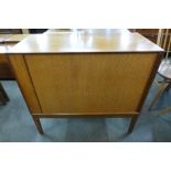 A teak tambour front cabinet