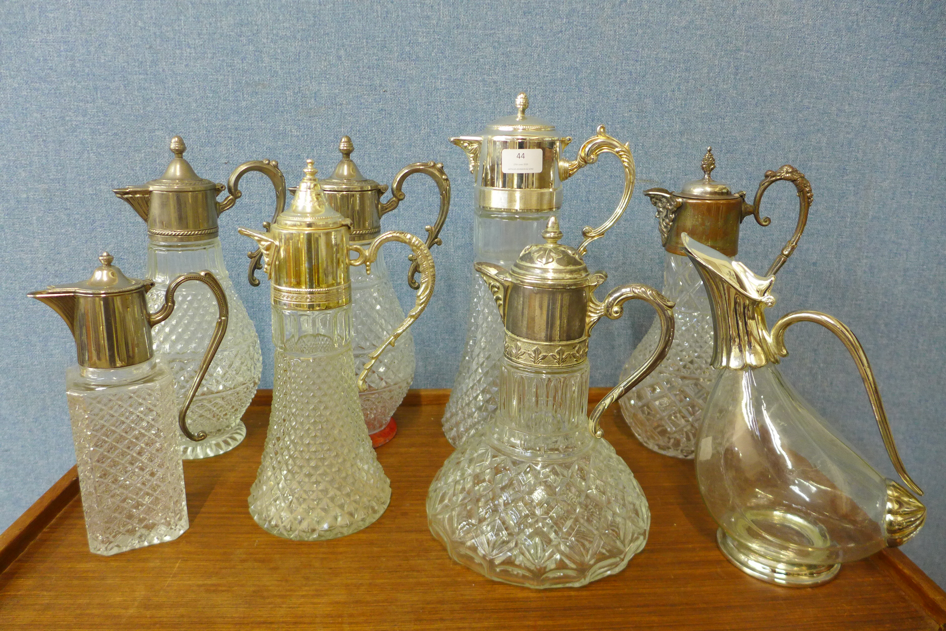 Eight plated glass claret jugs