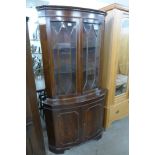 A mahogany bow front freestanding corner cabinet