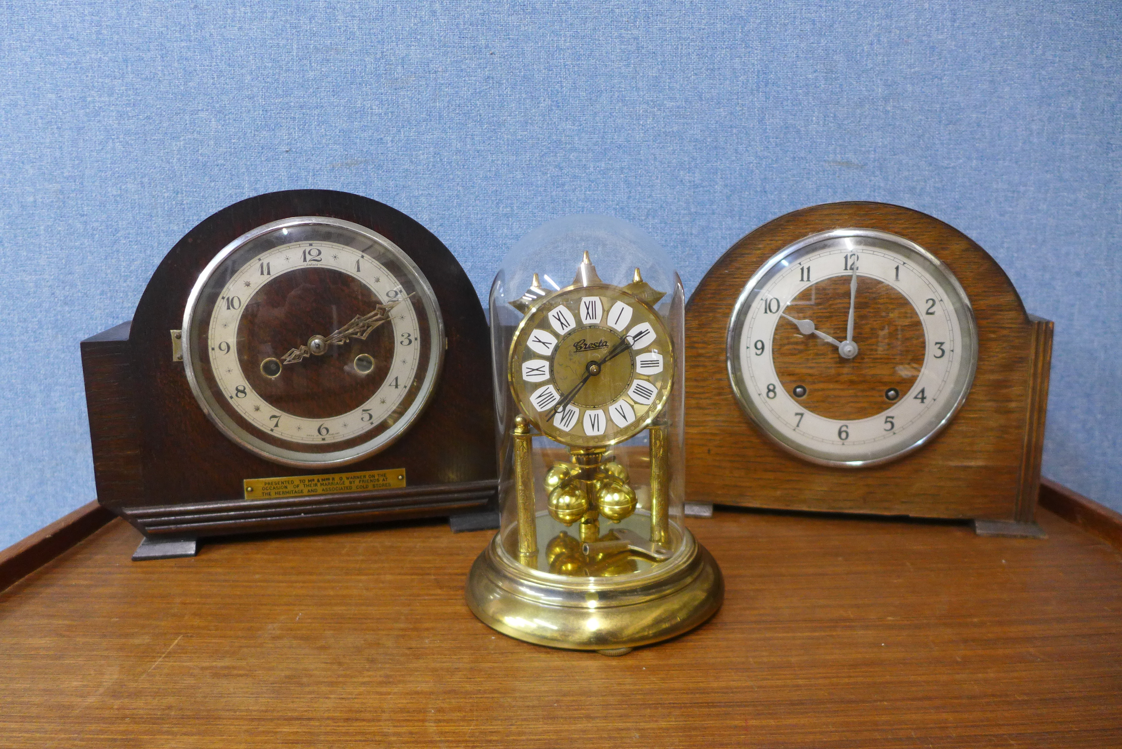 Two oak mantel clocks and a brass anniversary clock