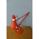 A red anglepoise desk lamp