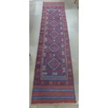 A hand knotted red ground runner rug, 258 x 63cm