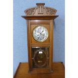 An early 20th Century oak wall clock