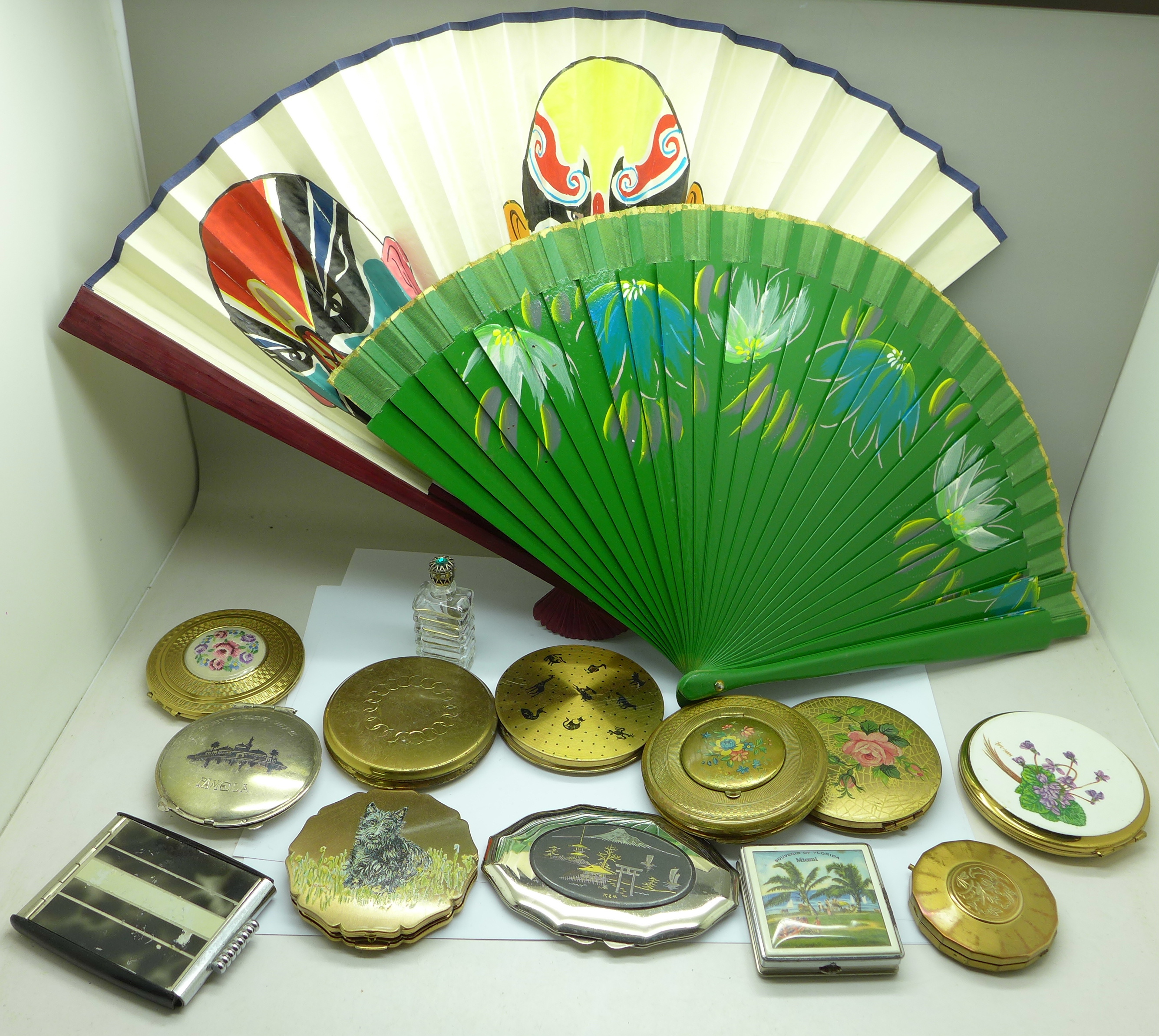 Twelve compacts including one white metal, a scent bottle and two fans