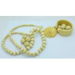 An antique carved ivory pendant, beads and a bangle