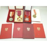 Four Polish medals with recipients booklets