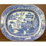 A large blue and white willow pattern meat platter, 53cm, a/f (chip and hairline crack to edge)