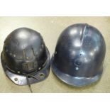 A miner's helmet and a French fireman's helmet