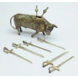 A white metal stand in the form of a bull with six small swords/olive sticks, length 7.5cm