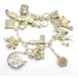 A silver charm bracelet with fifteen charms, 60.6g