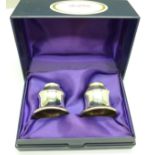 A pair of silver candle caps in a fitted case
